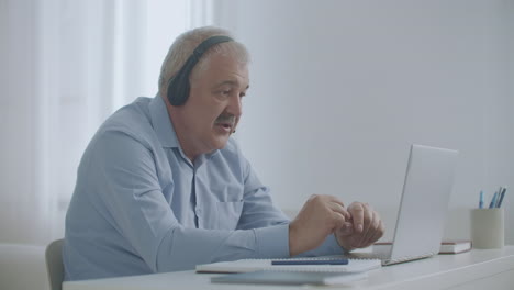 middle-aged-man-is-talking-by-video-chat-with-colleagues-working-remotely-connecting-with-departments